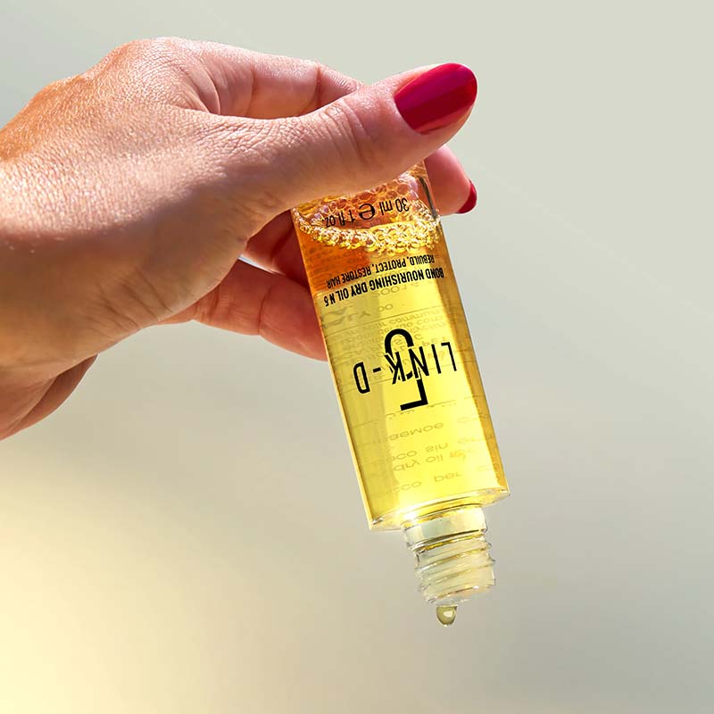 Una mano che manantiene dalla base un flacone trasparente.